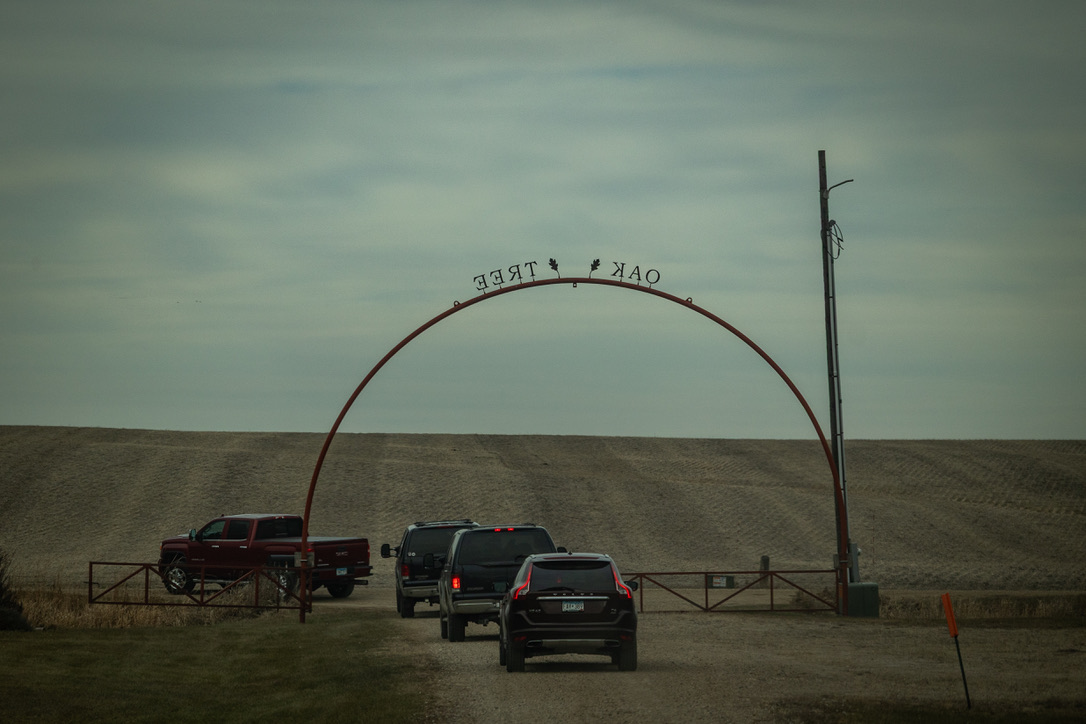 Trucks passing under the Oak Tree entrance arch