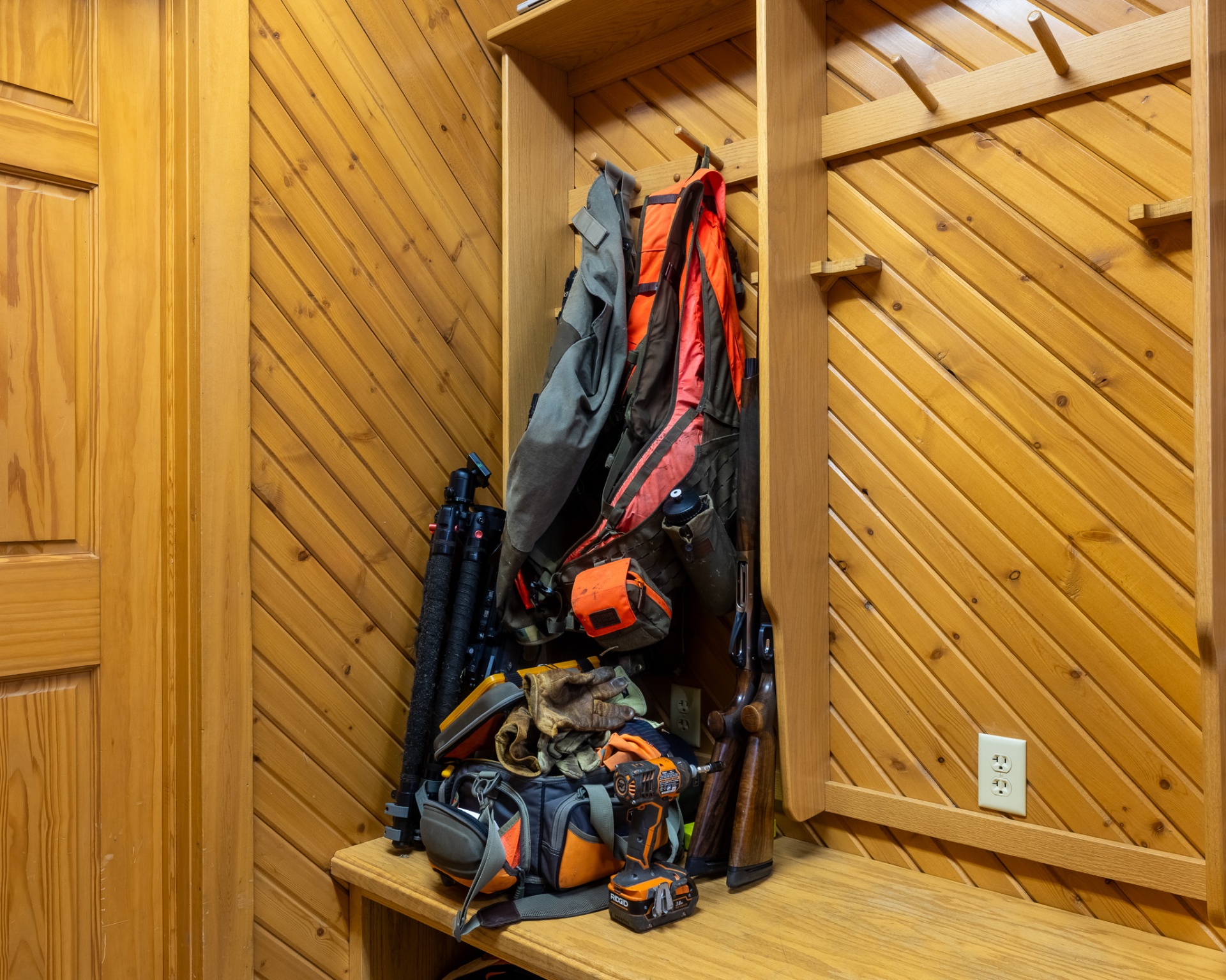A hunter's locker packed with vest, guns, and gear