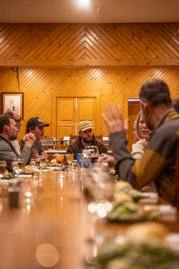 Guests around the long dinner table in the lodge